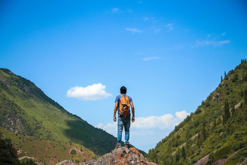 Man on Top of Mountain backing type of hiking