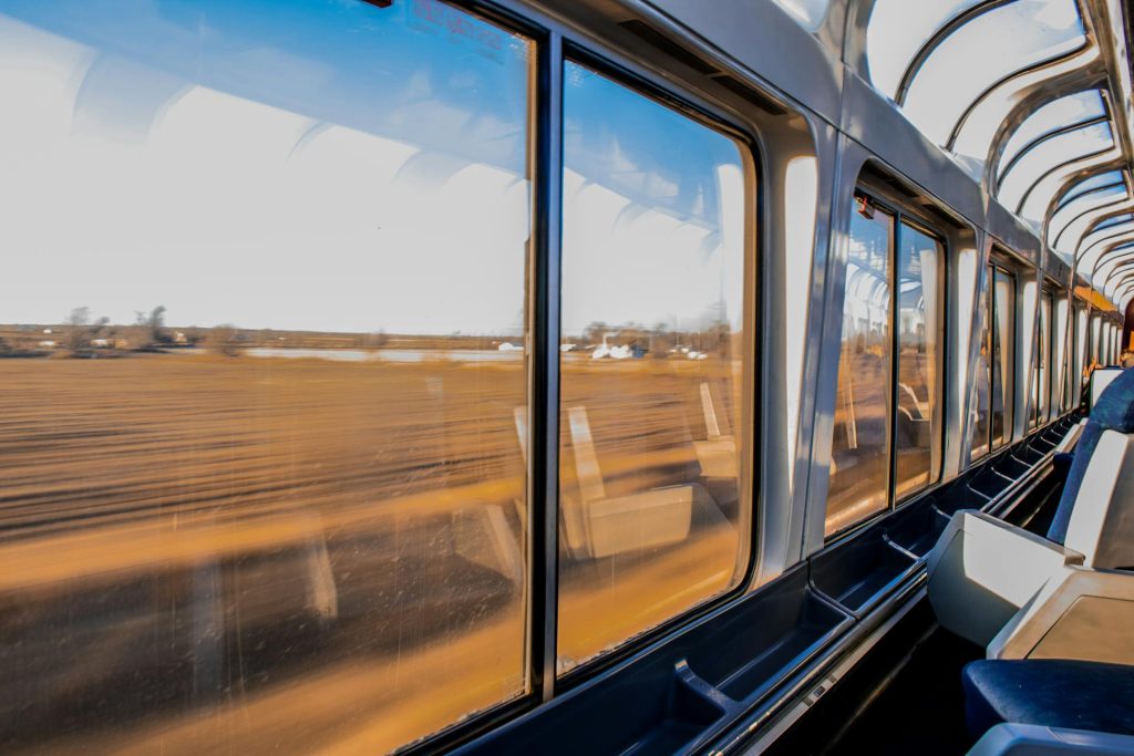 Person in Passenger Train Interior of a train with a view of the countryside, offering a scenic route to popular hiking destinations in Spain.