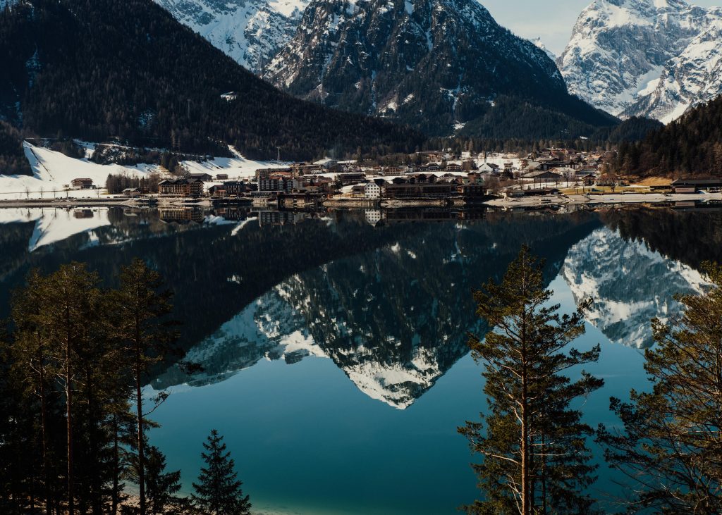 A stunning lake reflects the snow-capped Tyrolean Alps, a perfect destination for hiking holidays in Austria.