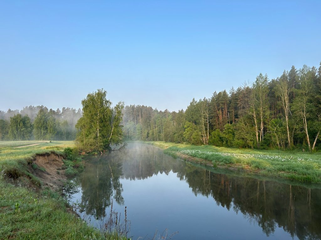 Peaceful river view with mist and trees at Anykščiai Regional Park, perfect for nature walks in Lithuania, showcasing stunning outdoor scenery and relaxation.