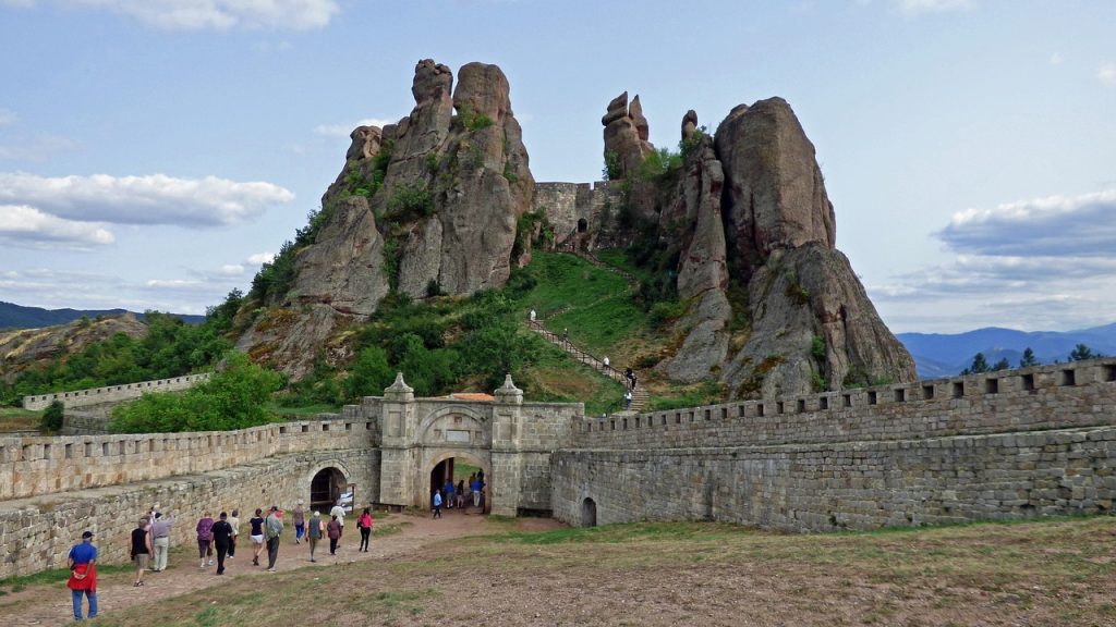 Visitors exploring the Belogradchik Rocks and fortress, with towering rock formations and ancient walls, offering a unique adventure in Bulgaria's natural landscape.