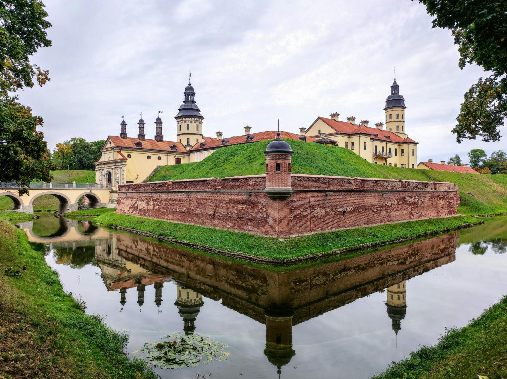 Mir Castle in Belarus with its historic walls and towers, surrounded by lush greenery and water, a top hiking spot to explore in Belarus.