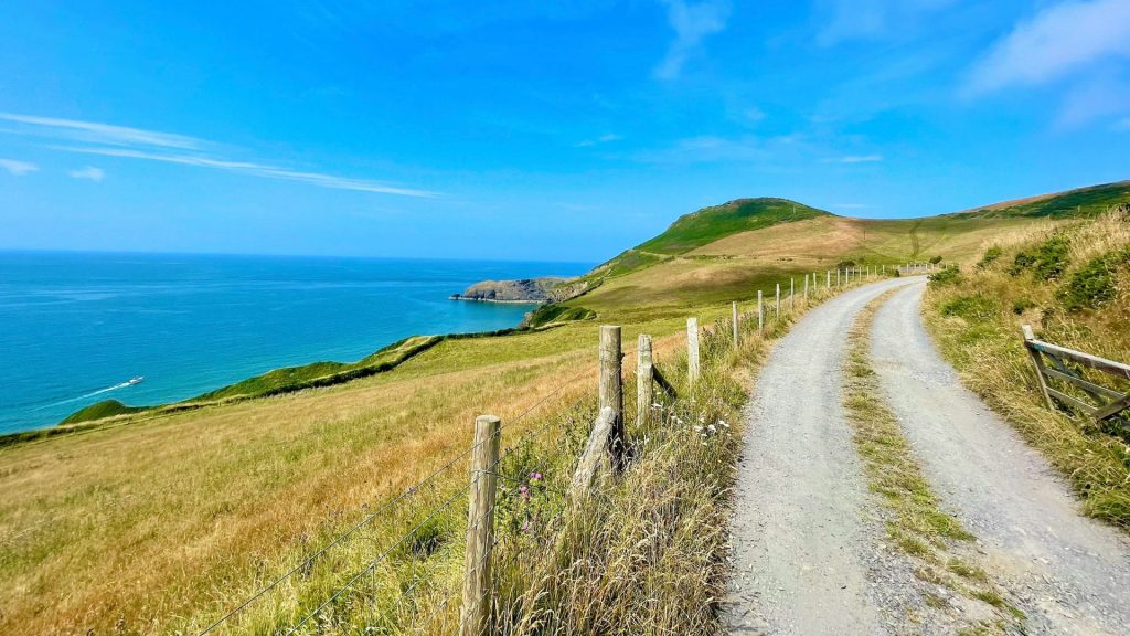 A winding gravel trail along the Wales Coast Path offers breathtaking coastal views, one of the best walking trails in Wales.