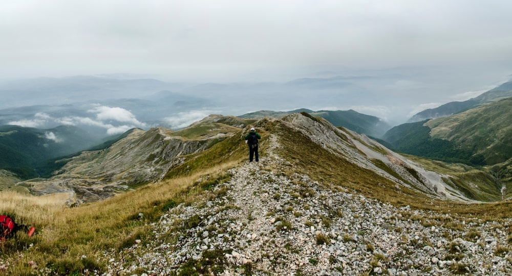A hiker walking along the Šar Mountains Ridge, offering breathtaking views and some of the best hiking trails in Kosovo.