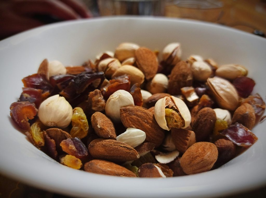 Portable hiking meal with a mix of almonds, pistachios, dried dates, and raisins, perfect for a nutritious snack during outdoor adventures.