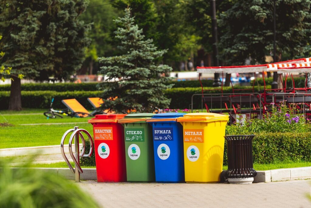 Colorful recycling bins in a public park promoting responsible waste disposal and Leave No Trace principles