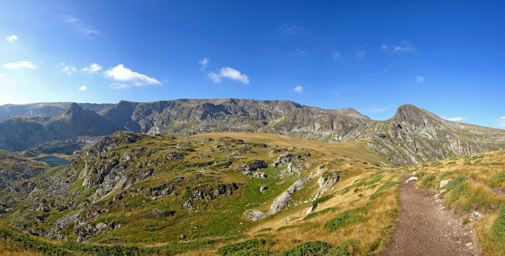 Scenic mountain landscape with a clear trail leading toward the peaks, part of the famous Seven Rila Lakes Trail in Bulgaria.