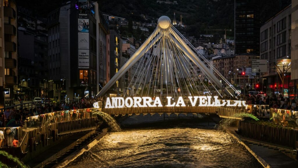 Night view of Andorra la Vella city center with illuminated bridge and river, gateway to the best hikes in Andorra la Vella.