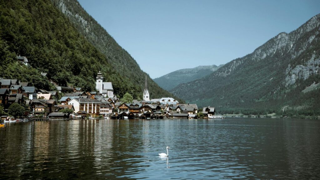 Charming lakeside village in Hallstatt, Austria with alpine mountains and a swan on the lake