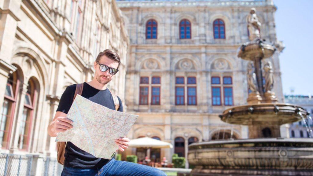 Tourist exploring Vienna city center with historic architecture and fountain, perfect for a Vienna city guide and travel planning.