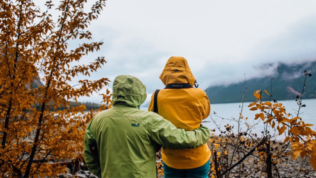 Waterproof Jackets Buyer’s Guide for Hiking & Walking Holidays with hikers wearing rain jackets beside a misty lake.