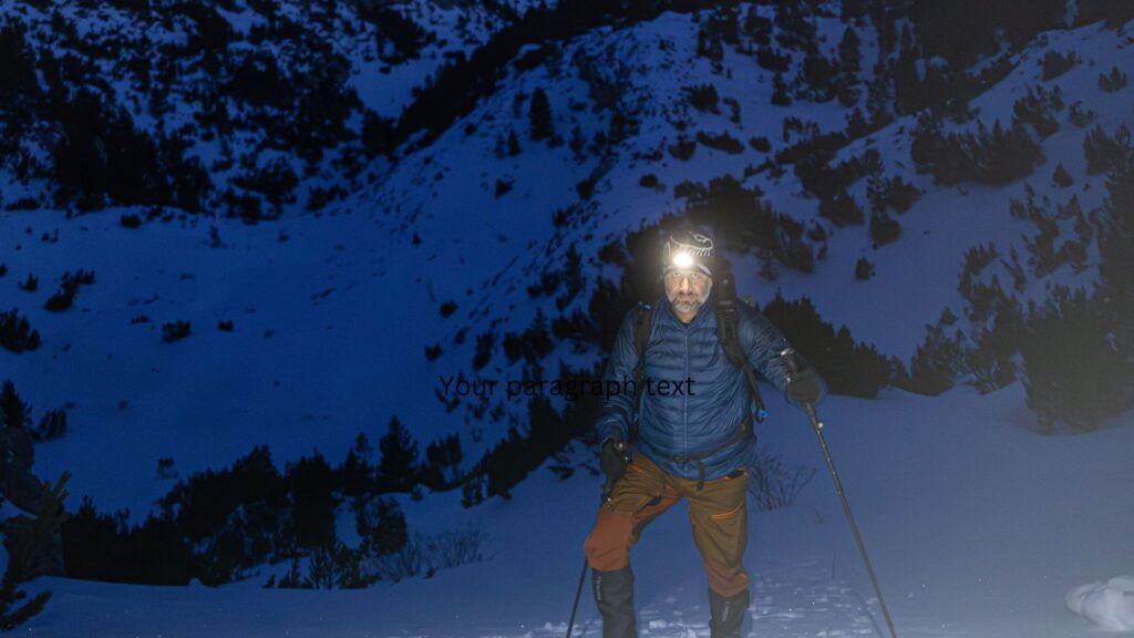 Headtorch Buyer’s Guide for Hiking & Walking Holidays: hiker using a headtorch on a snowy mountain trail at dawn.