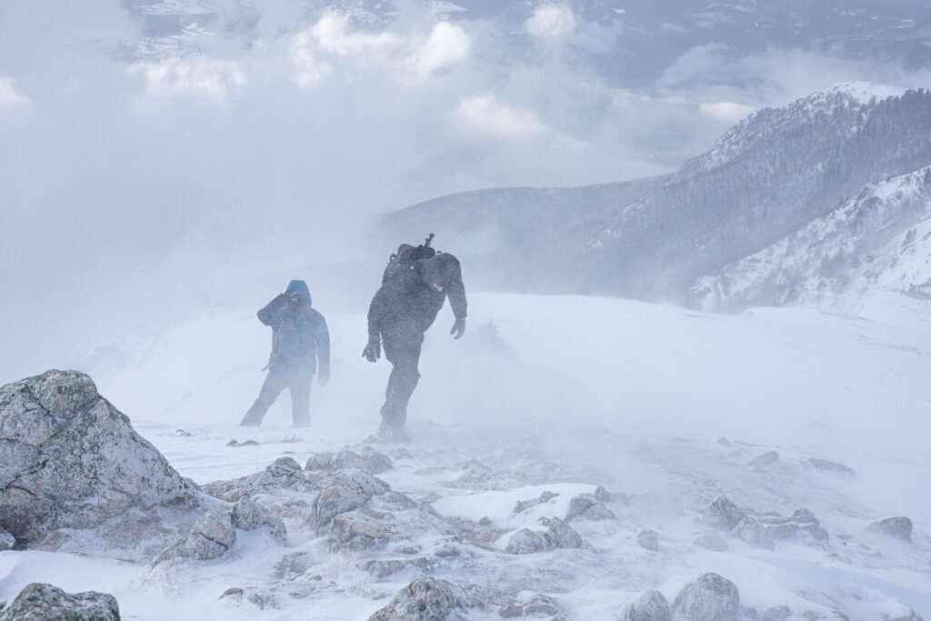 Hiker dressed in layers while hiking in Cool, Windy, or Changeable Conditions on an exposed mountain trail.