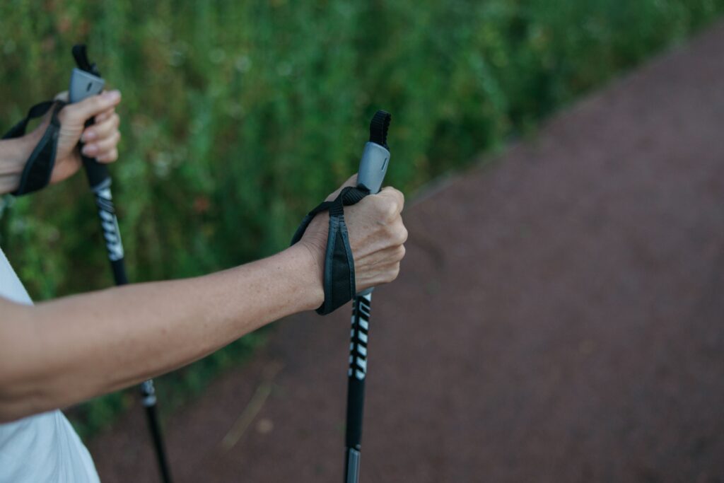 Hiker gripping trekking poles with wrist straps, How Trekking Poles Fit Into Your Overall Setup for comfort and support.