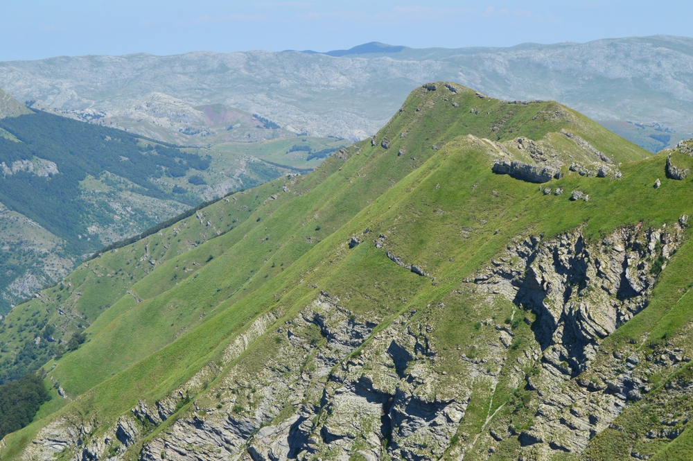 Visočica ridge in Bosnia showcasing rolling green peaks, rugged limestone cliffs, and scenic mountain hiking trails