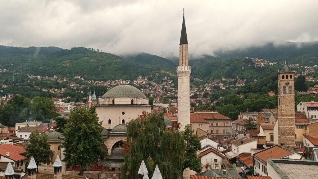 Panoramic city view near the best hikes in Sarajevo, featuring historic landmarks, forested hills, and mountain scenery.