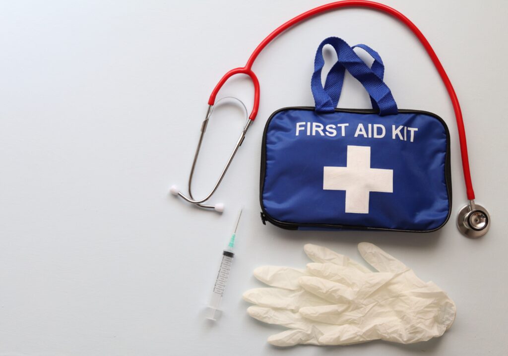 First Aid Essentials for Hiking with first aid kit, gloves, syringe, and stethoscope for emergency trail preparedness.