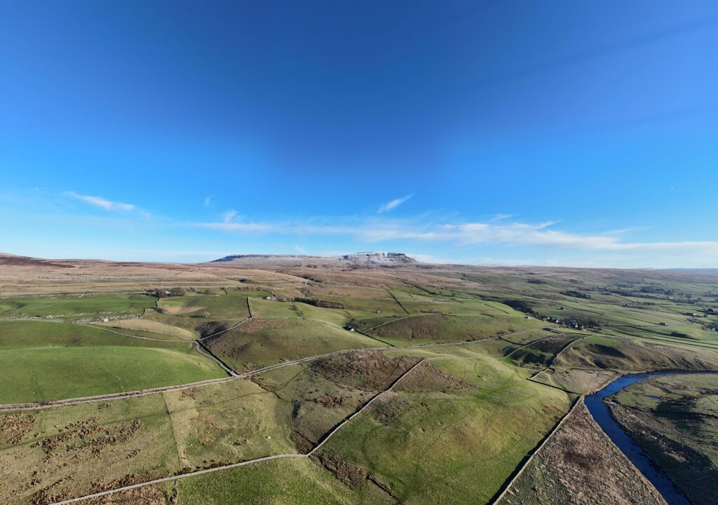 Panoramic view of Pen y ghent Yorkshire with rolling green fields dry stone walls and the Yorkshire Dales landscape