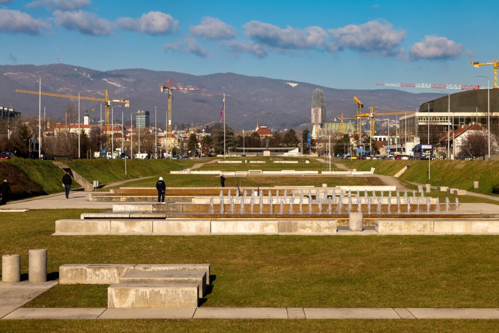 Zagreb skyline with fountains, city park, and mountains in the background on a clear day in Zagreb.