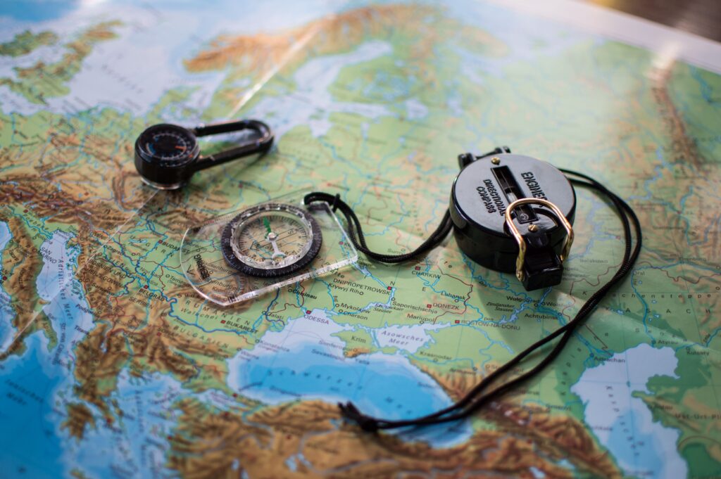 Maps and navigation tools including compasses and a topographic map for safe hiking route planning and outdoor adventures.
