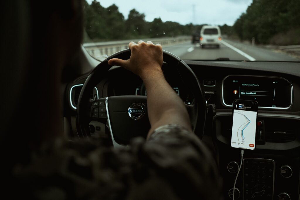 Driver using phone base navigation app for directions during a road trip to a hiking trailhead.