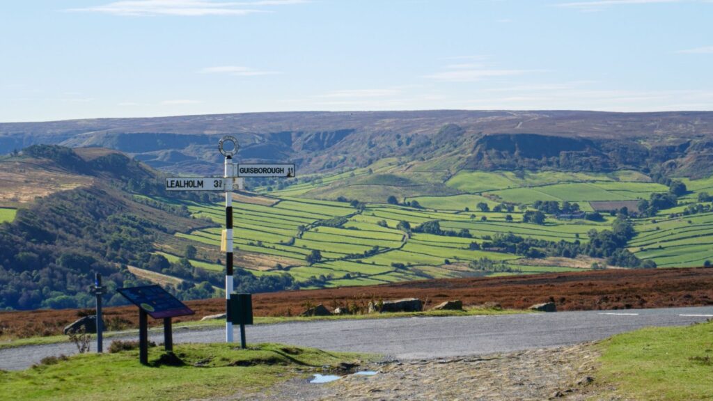 Best Walks Yorkshire Moors with scenic views of rolling hills green valleys and a historic trail sign