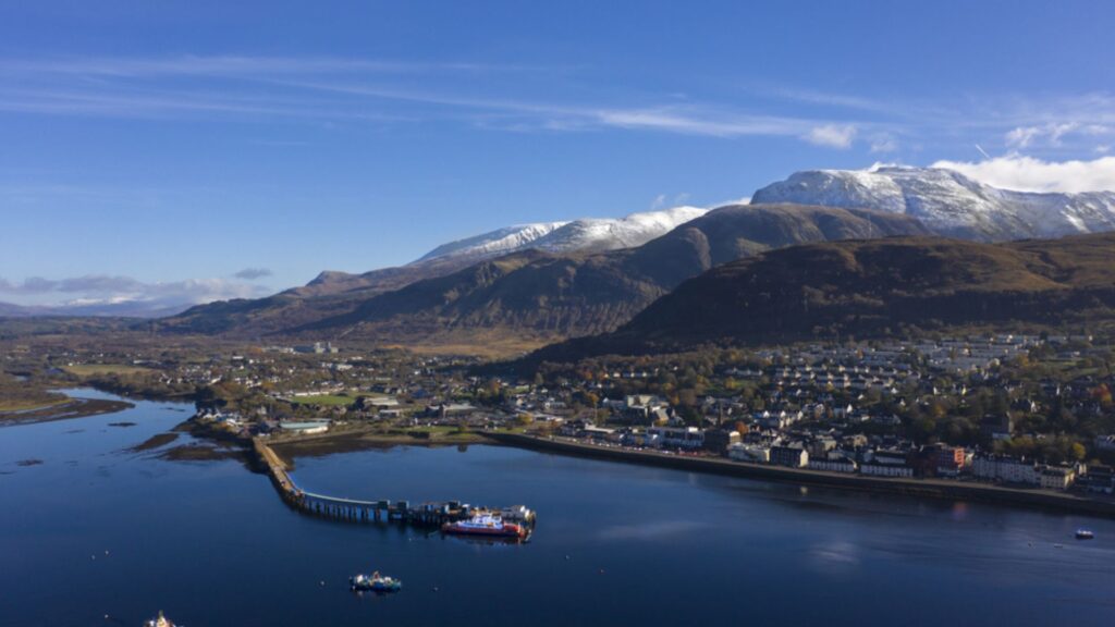 Hikers Guide to Fort William Scotland showcasing the town waterfront and surrounding snow capped Highland mountains