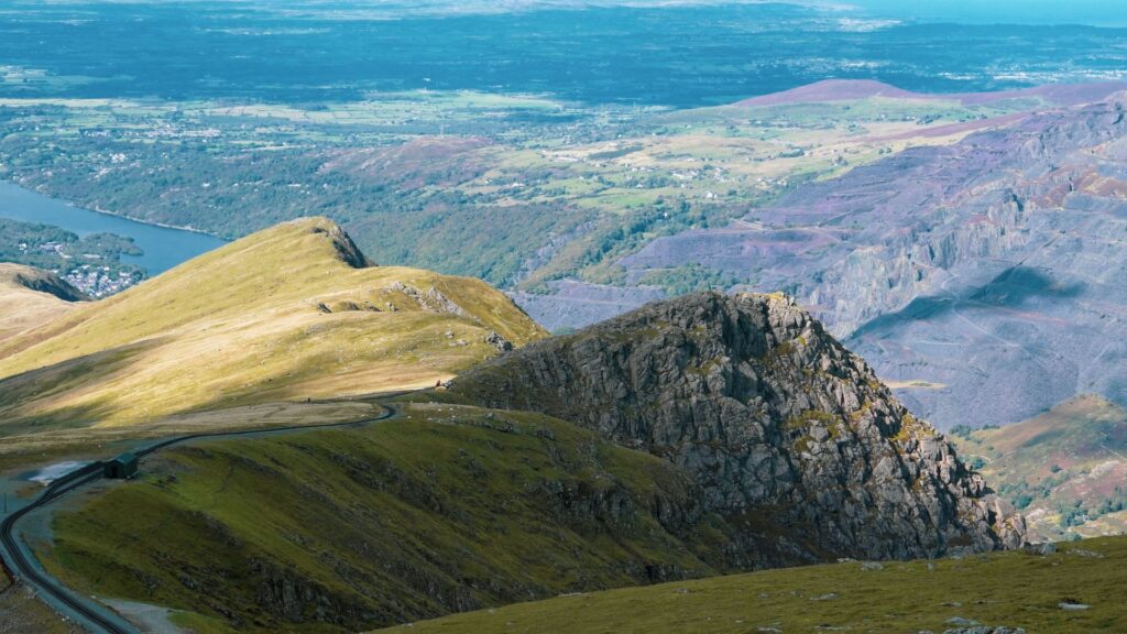 Snowdonia Slate Trail with rugged mountain ridges, slate quarry, green hills, and a scenic lake in Wales.