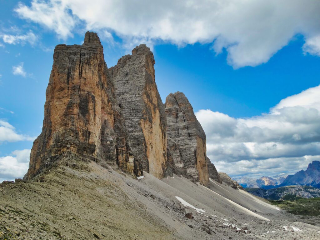 Tre Cime and the Sexten Dolomites italy Kayde Parker Dramatic rock towers of Tre Cime and the Sexten Dolomites under a blue sky