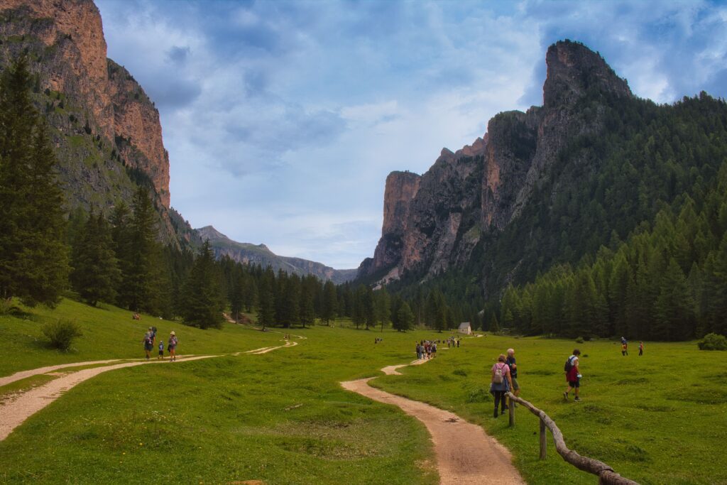 Val Gardena nortern italy Kayde Parker Scenic hiking trail through a green alpine valley surrounded by dramatic peaks in Val Gardena Italy